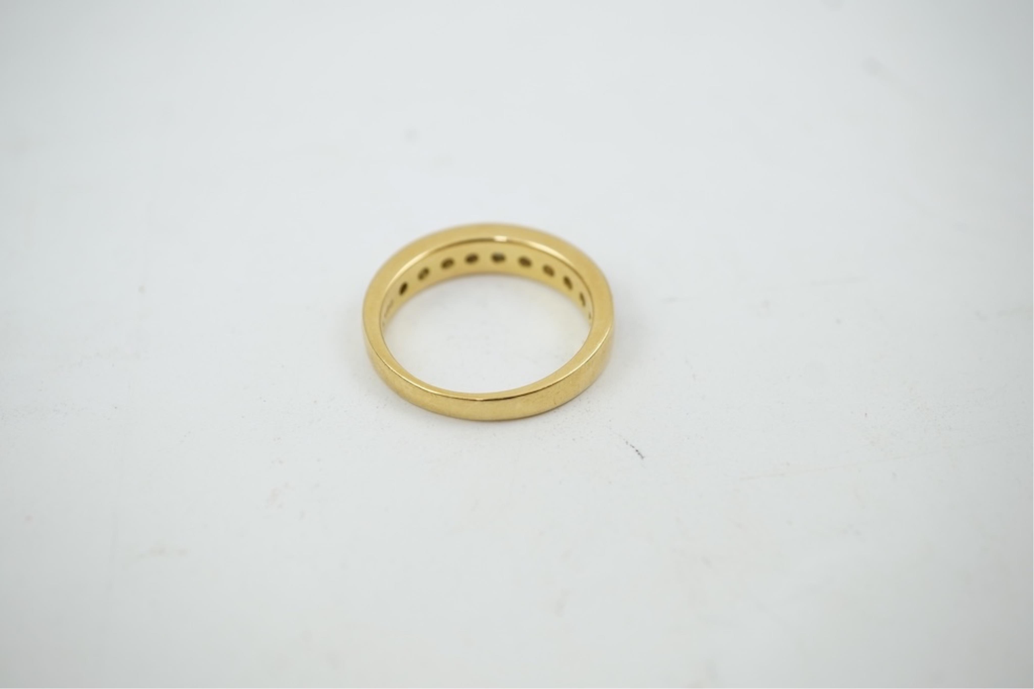 A modern 18ct gold and channel set graduated ten stone diamond set half eternity ring, size Q, gross weight 5.4 grams.
